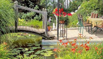 Brücke führt über den Teich zu einer gemütlichen Sitzecke | Garten- + Landschaftsbau Heiner Monninkhof Bad Bentheim